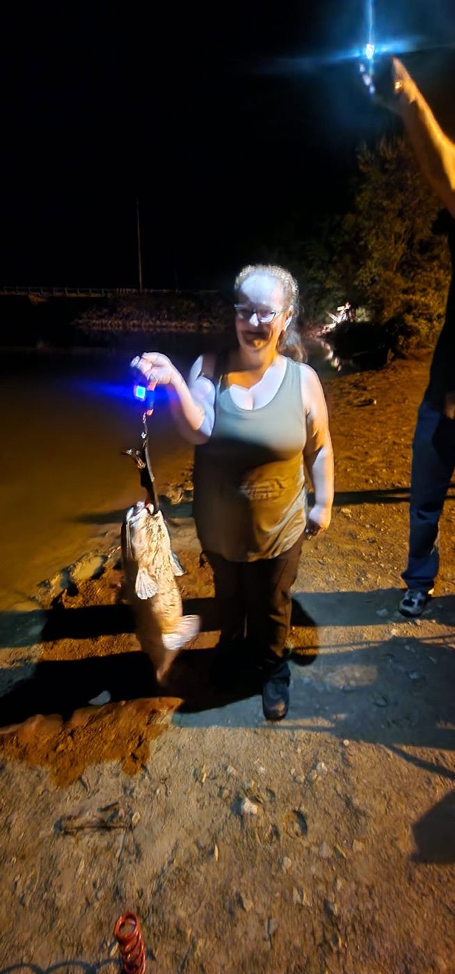 Renea holding a catfish at night